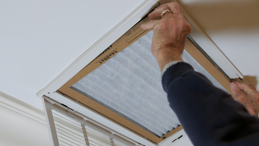 Man replaces air filter to improve indoor air quality